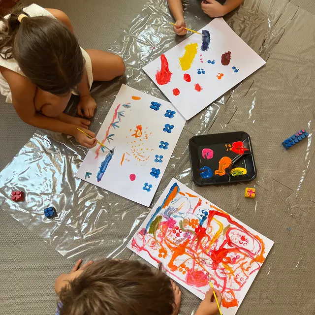 Crianças pintando com as mãos na aula de Artes e Movimento do Musicalisa, em Mococa