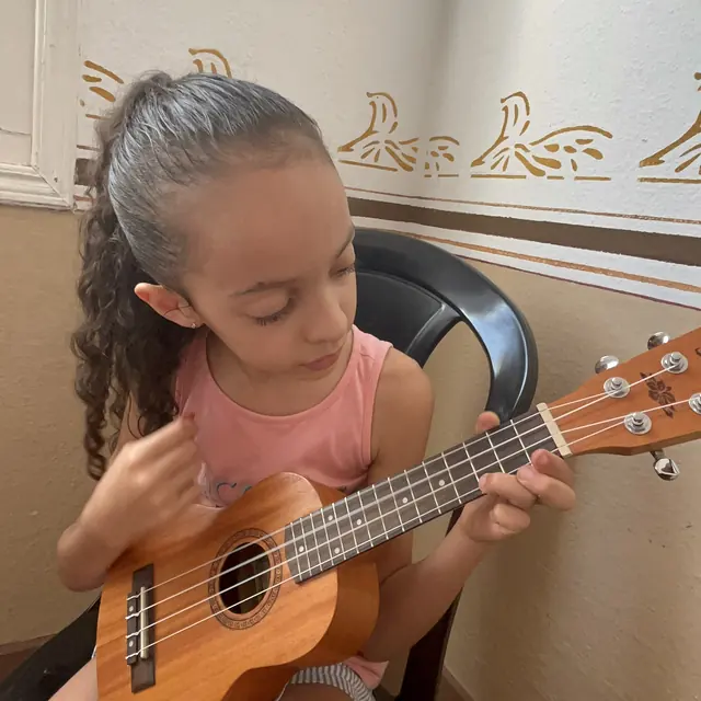 Menina tocando ukulele em aula no Musicalisa, em Mococa
